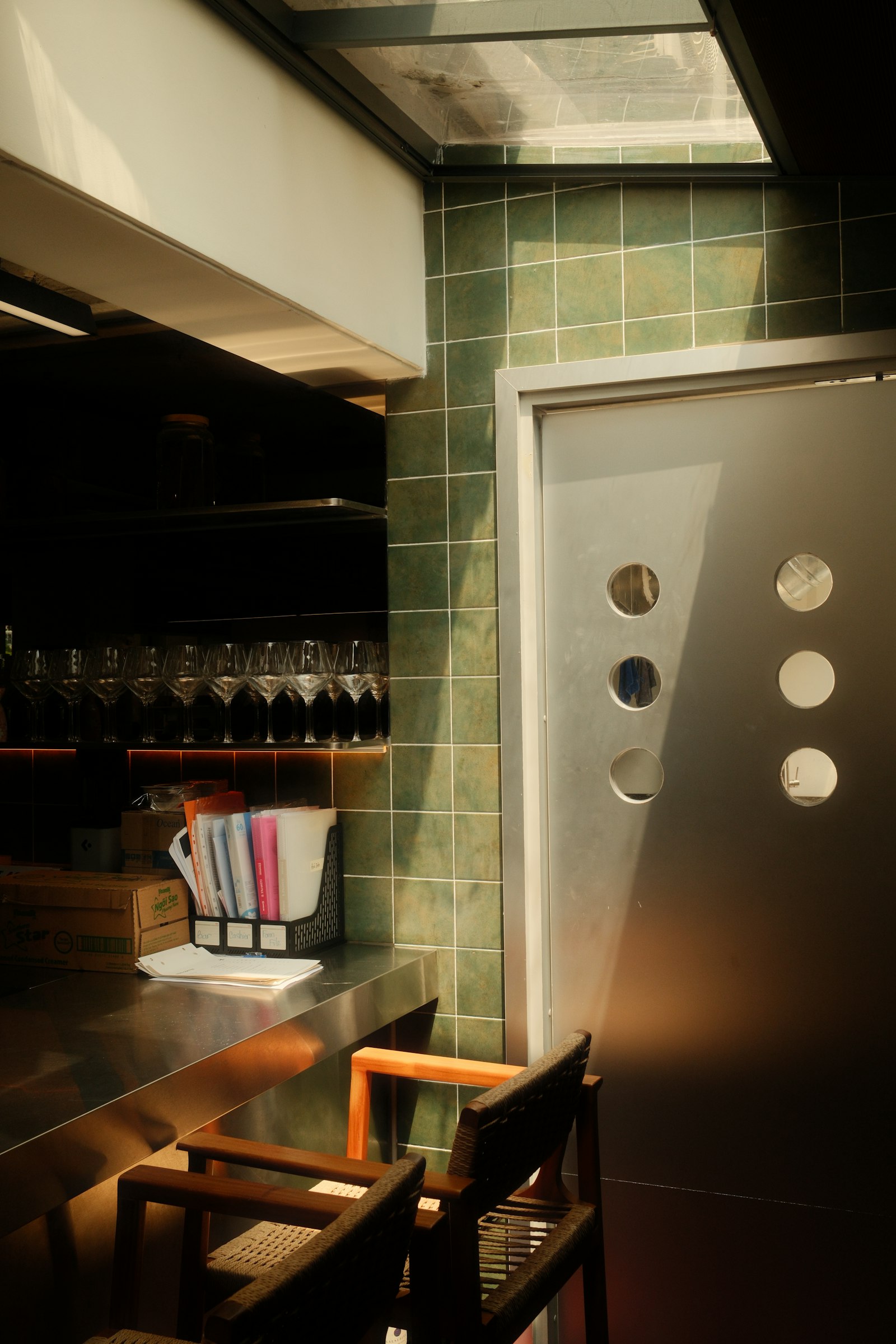 Napoli, Soderini Milano – bar moderno illuminato dal sole con parete piastrellata verde e porta di metallo