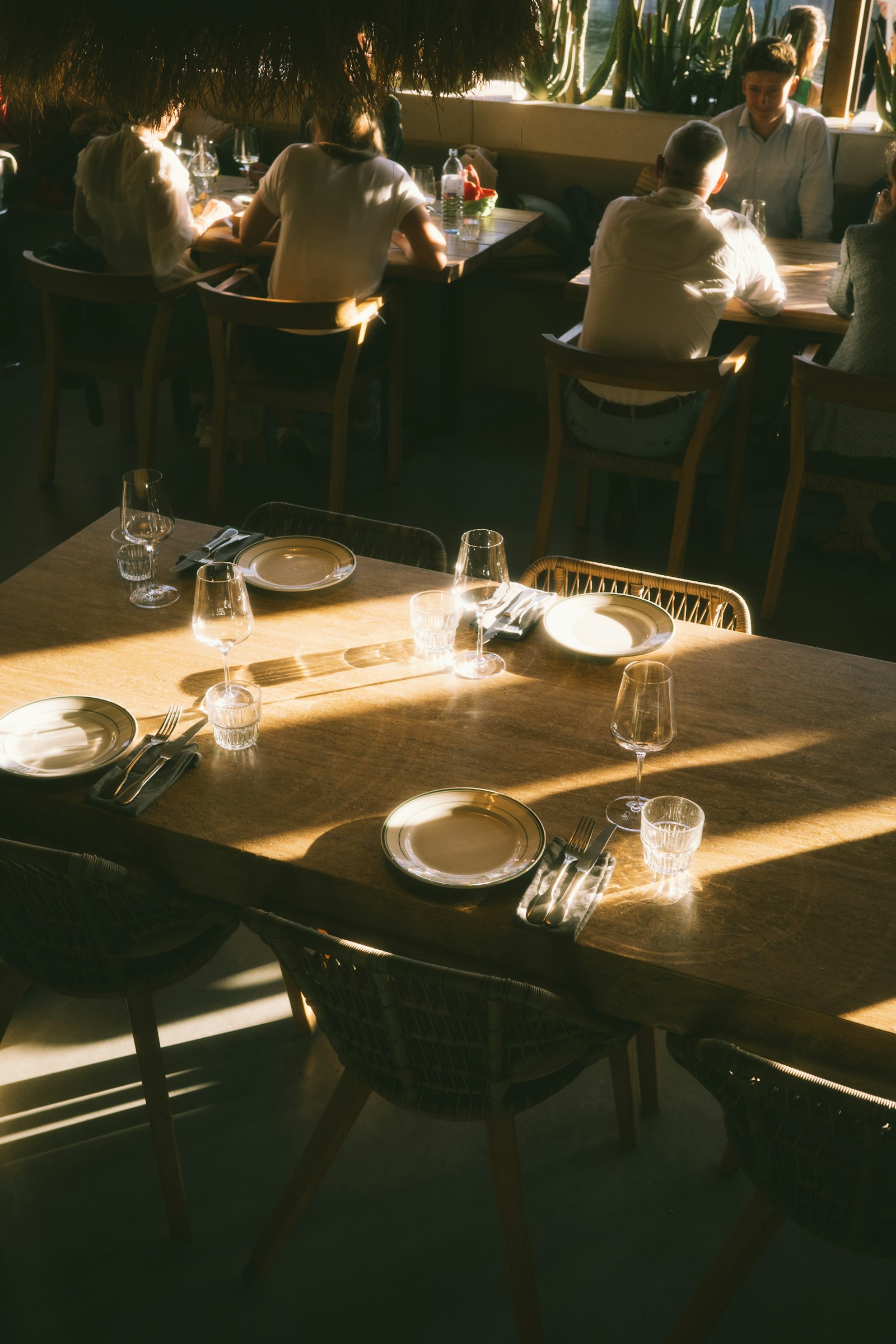 Quanto spendere Milano – persone che cenano al tavolo di un ristorante illuminato dal sole