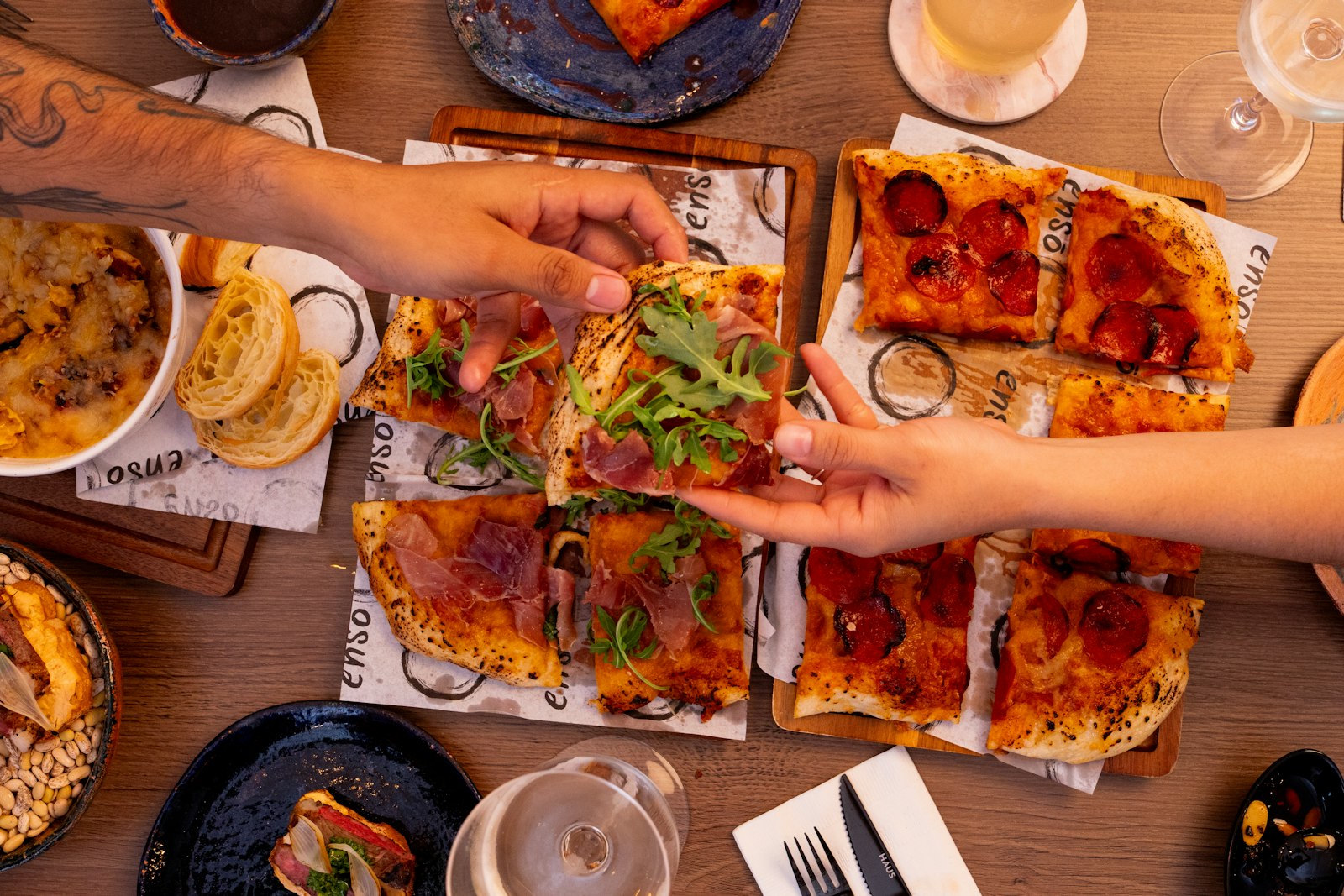 Solari, Washington Milano – persone che condividevano varie pizze e antipasti a un tavolo